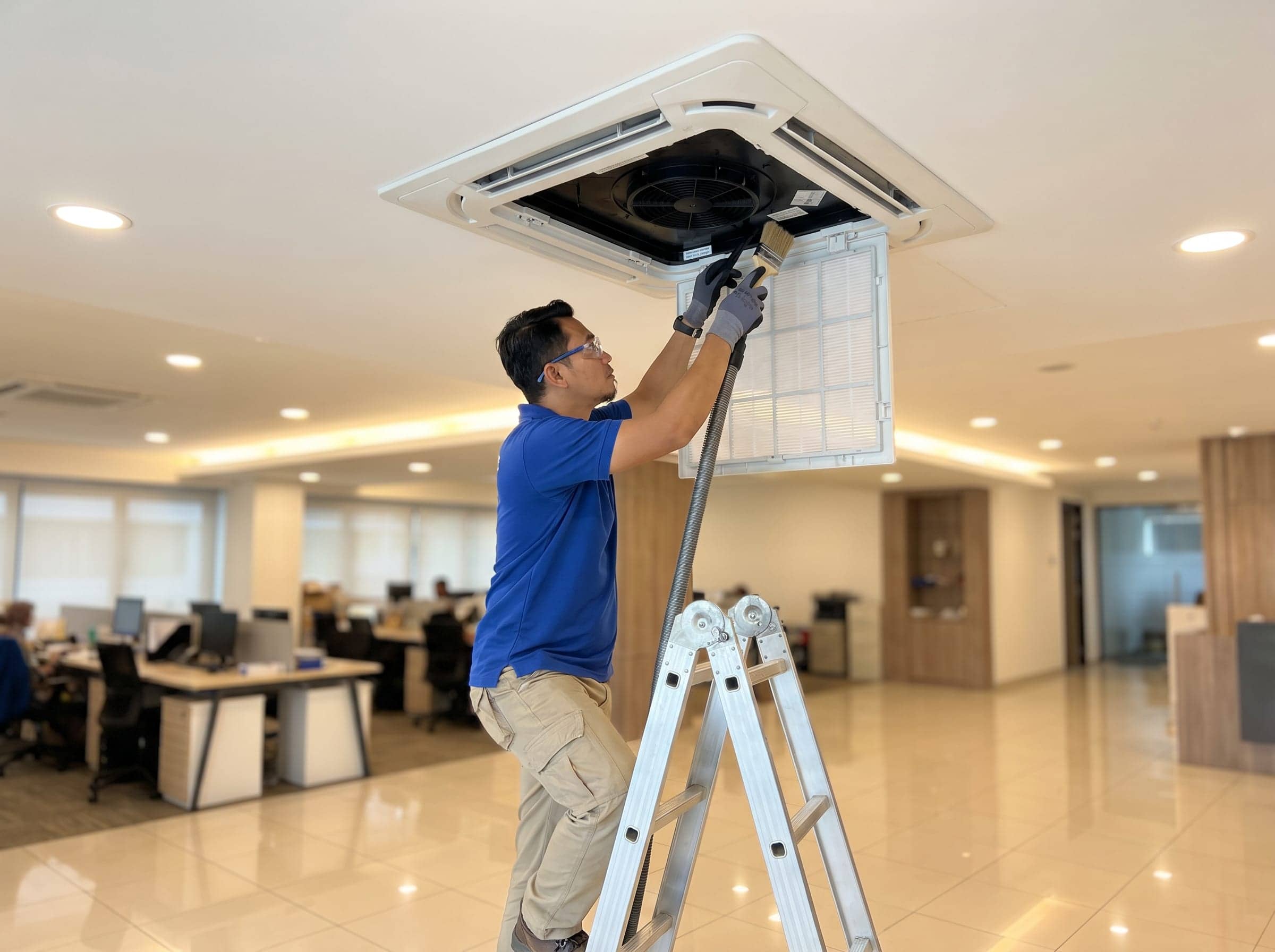 Mavis Eco Cool technician servicing ceiling cassette aircond in a Kuala Lumpur office